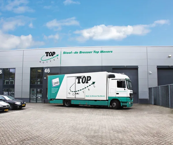 Het pand van Stoof de Bresser Top Movers aan de Mijkenbroek 46 in Breda, met een verhuiswagen ervoor