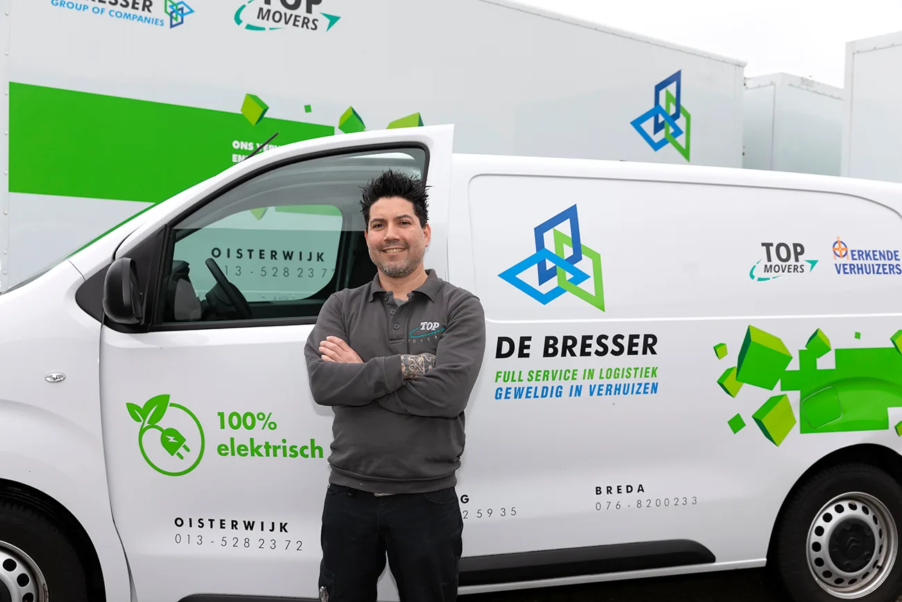 Medewerker van De Bresser met de armen over elkaar voor een elektrische bestelbus van De Bresser