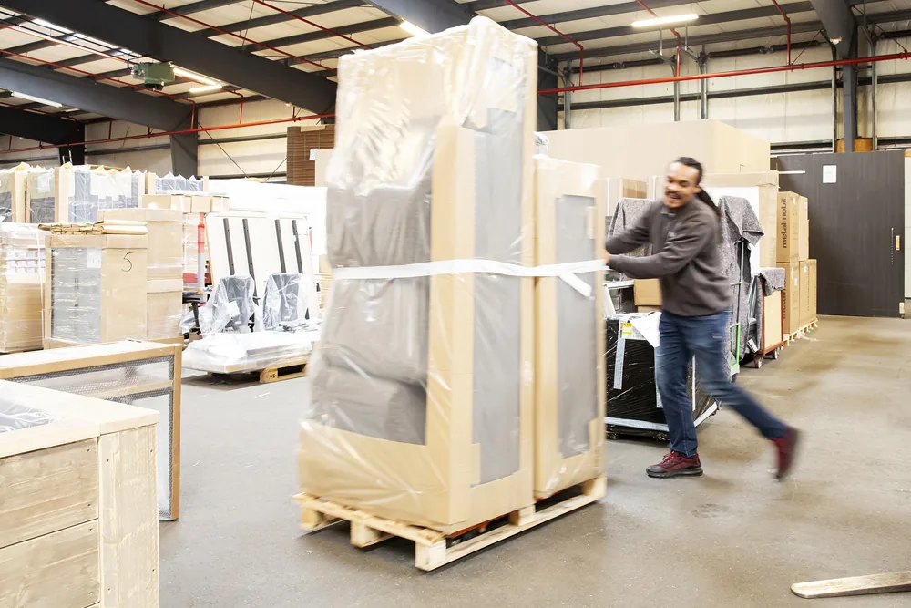 Magazijn met ingepakt meubilair op pallets, klaar voor transport