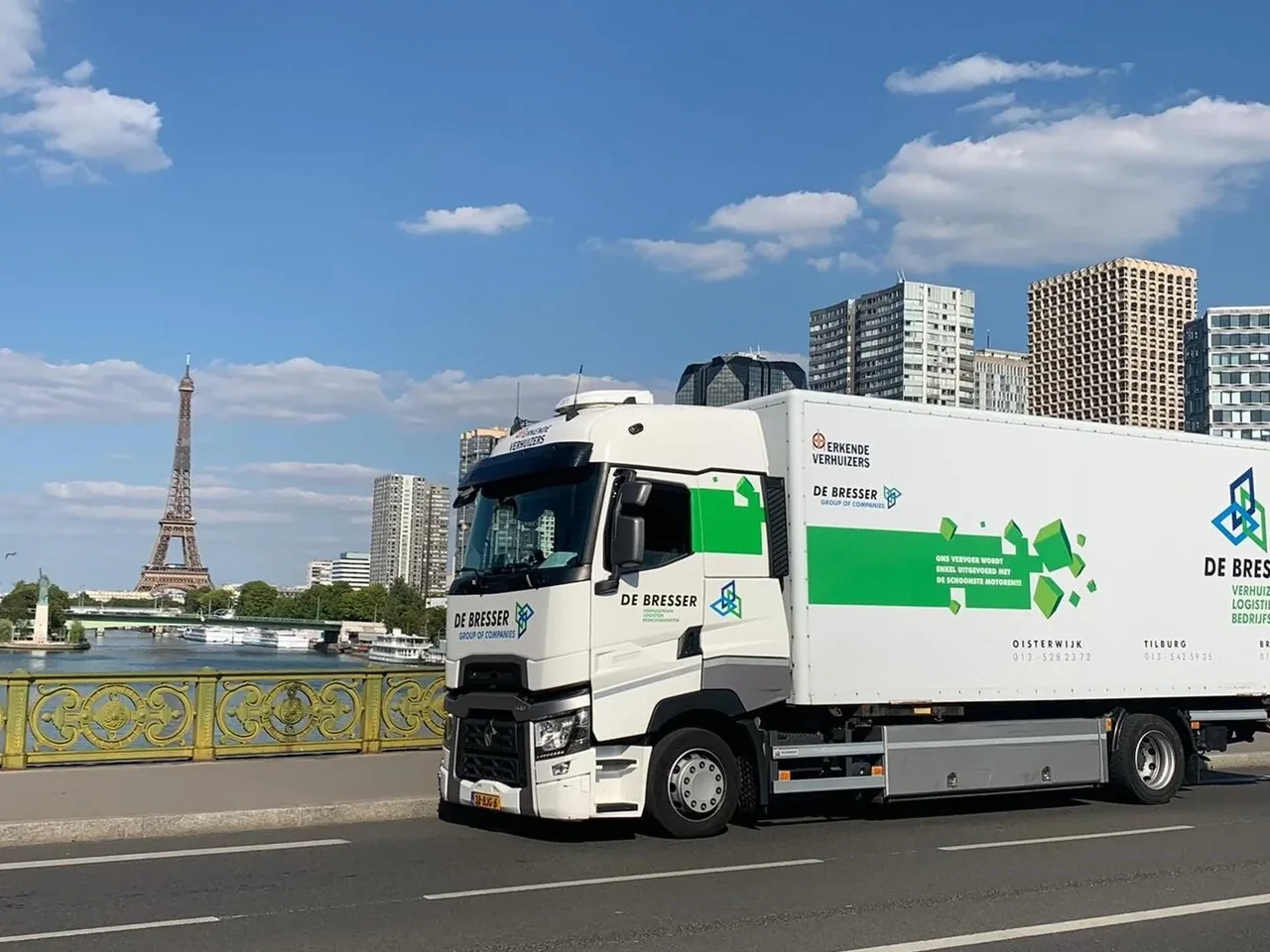 Vrachtwagen van De Bresser op een brug, met de Eiffeltoren op de achtergrond