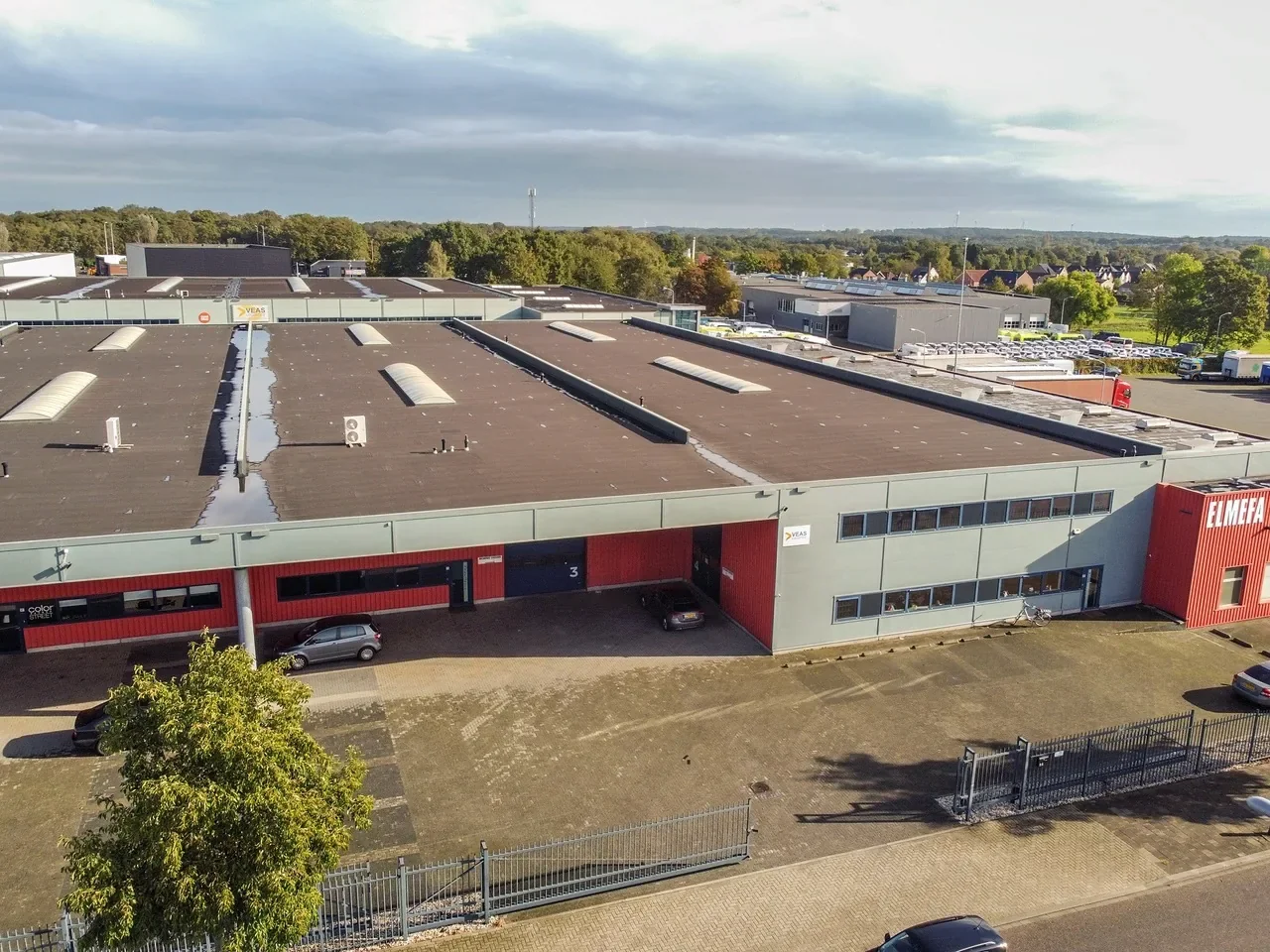 Luchtfoto van een bedrijfspand met een plat dak op een bedrijventerrein