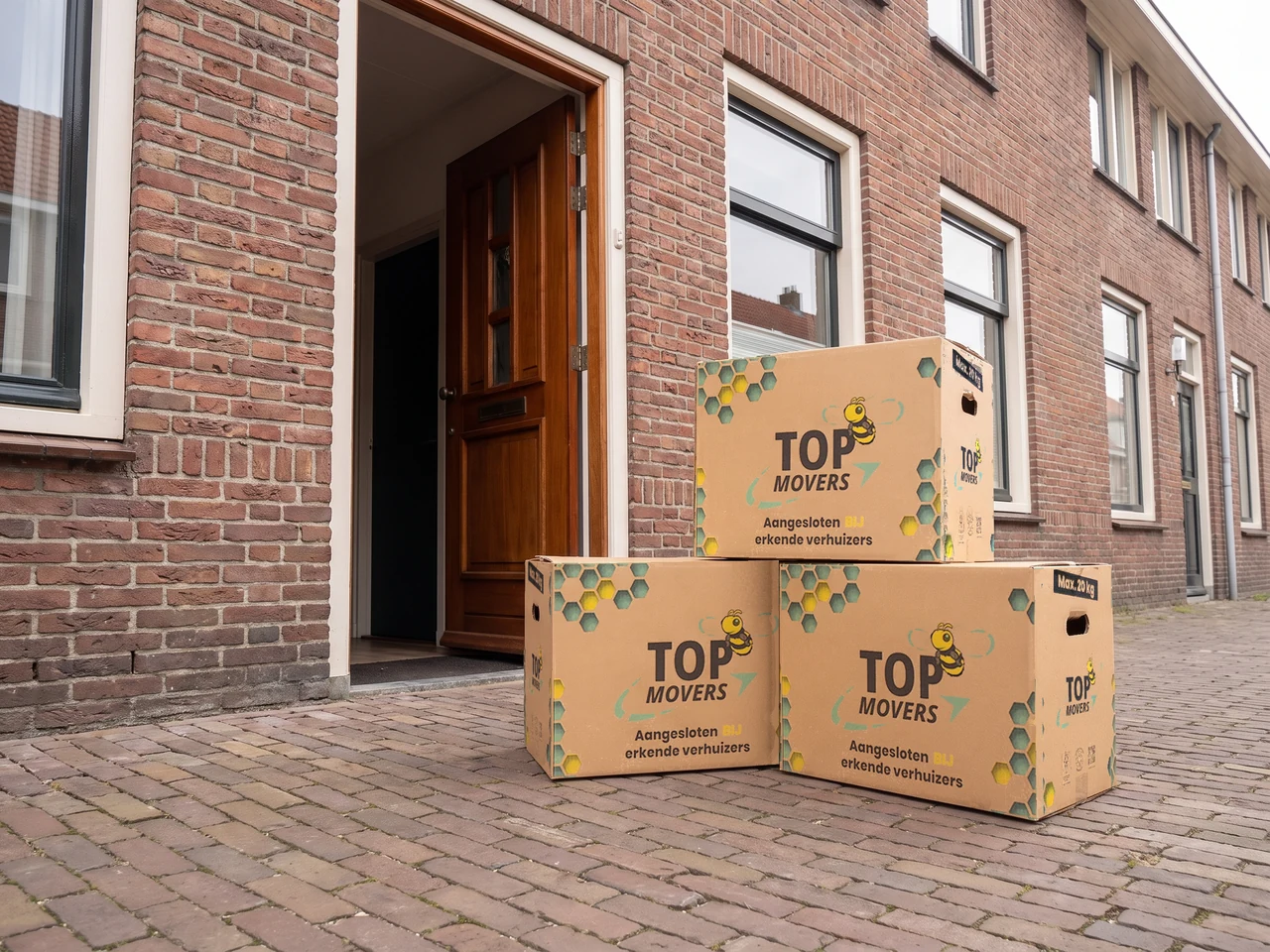 Top Movers-verhuisdozen bij de voordeur van een woning