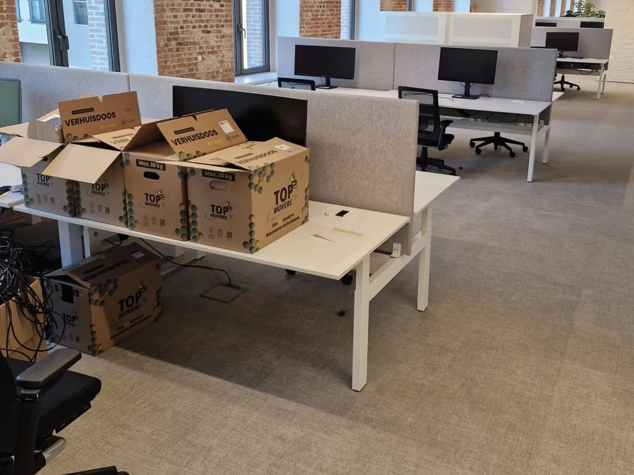 Kantoortuin met verhuisdozen van Top Movers op de bureaus