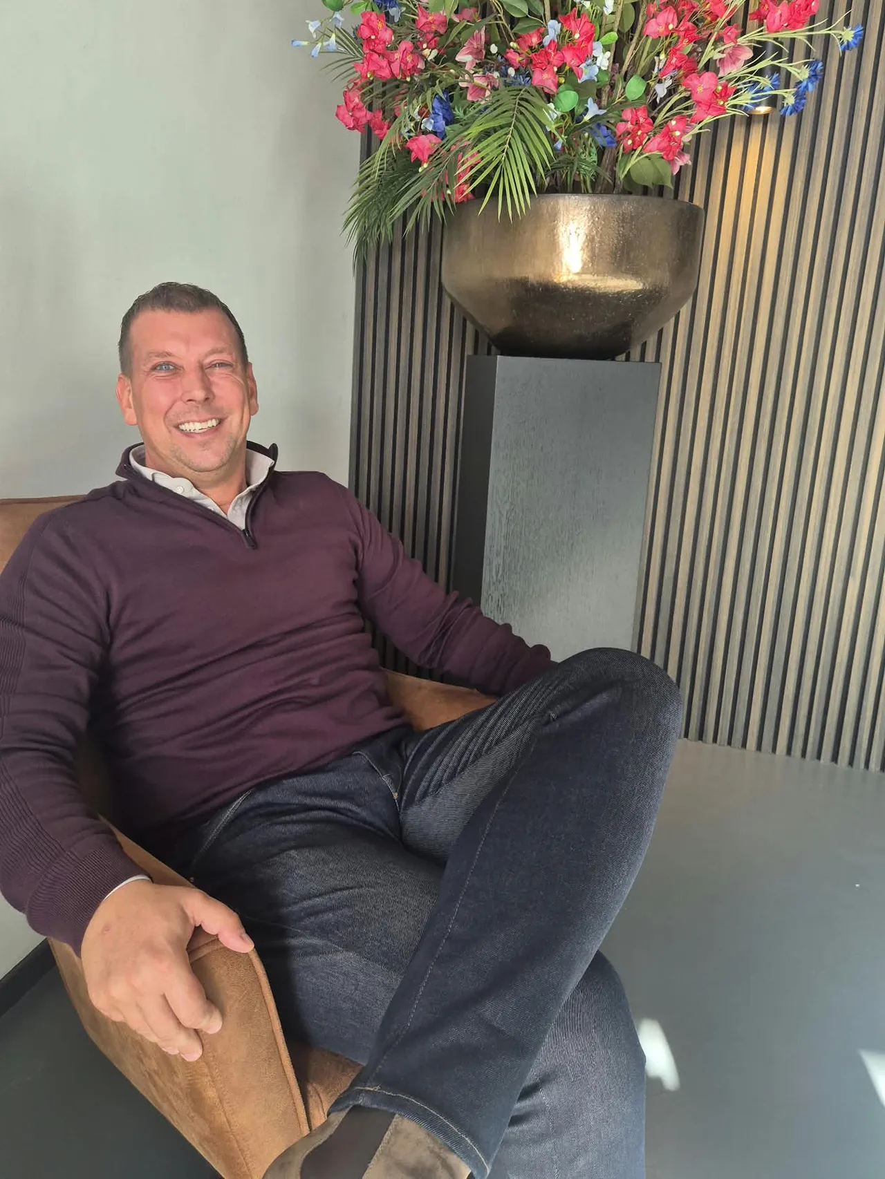 Tomas Brands, algemeen directeur van De Bresser, lachend in een leren fauteuil