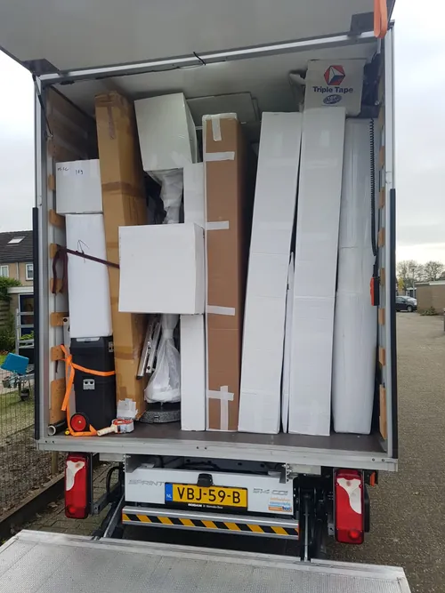 Open laadruimte van een verhuiswagen met ingepakte panelen en spanbanden